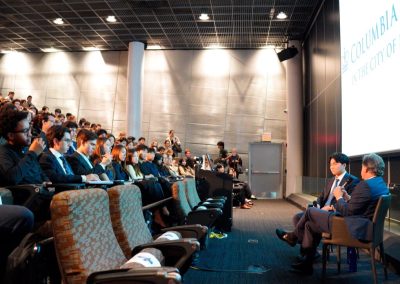 Siyang Ding of Weston Talks holds a microphone while moderating the conversation with Blair Effron of Centerview Partners